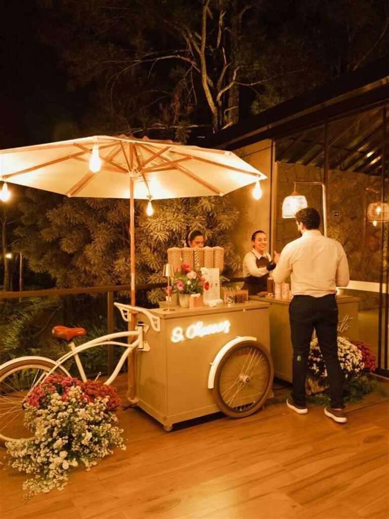 Equipe do Ateliê O Churros atendendo convidados no carrinho gourmet à noite