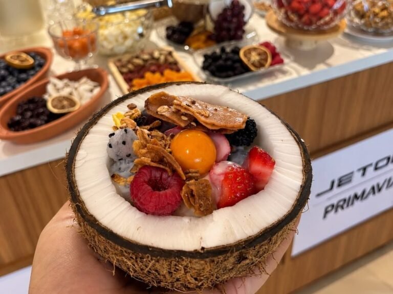 Frutas frescas, secas e iogurte servidos em meio coco
