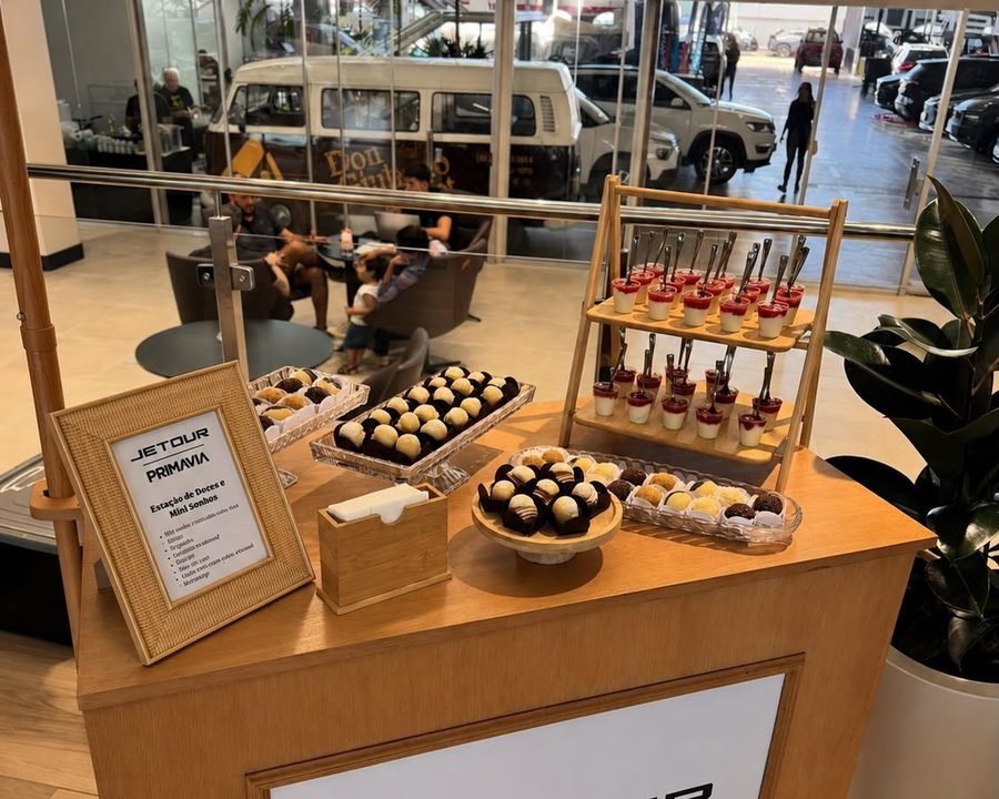 Mesa de docinhos e mini sonhos em evento corporativo